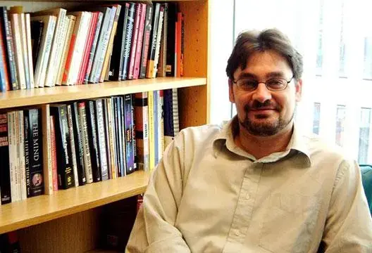 Mark Griffiths, Autor und Professor, sitzt neben einem Bücherregal in einem akademischen Büro